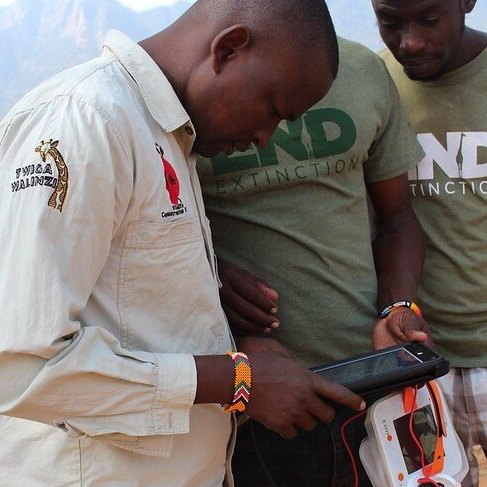 Men charging a device with a luminaid lantern.