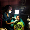 Dentist using a luminaid light to help take care of a child. 